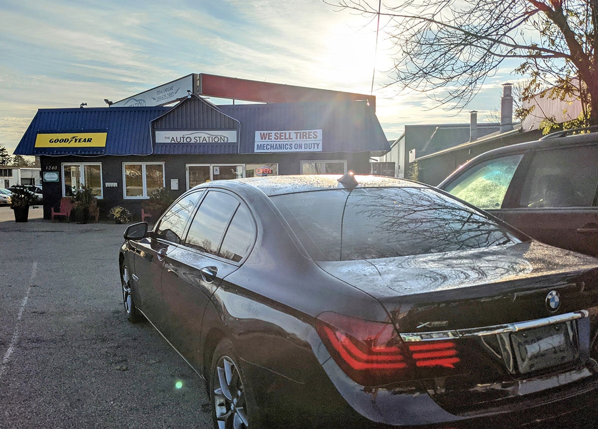 BMW parked in front of The Auto Station at dusk